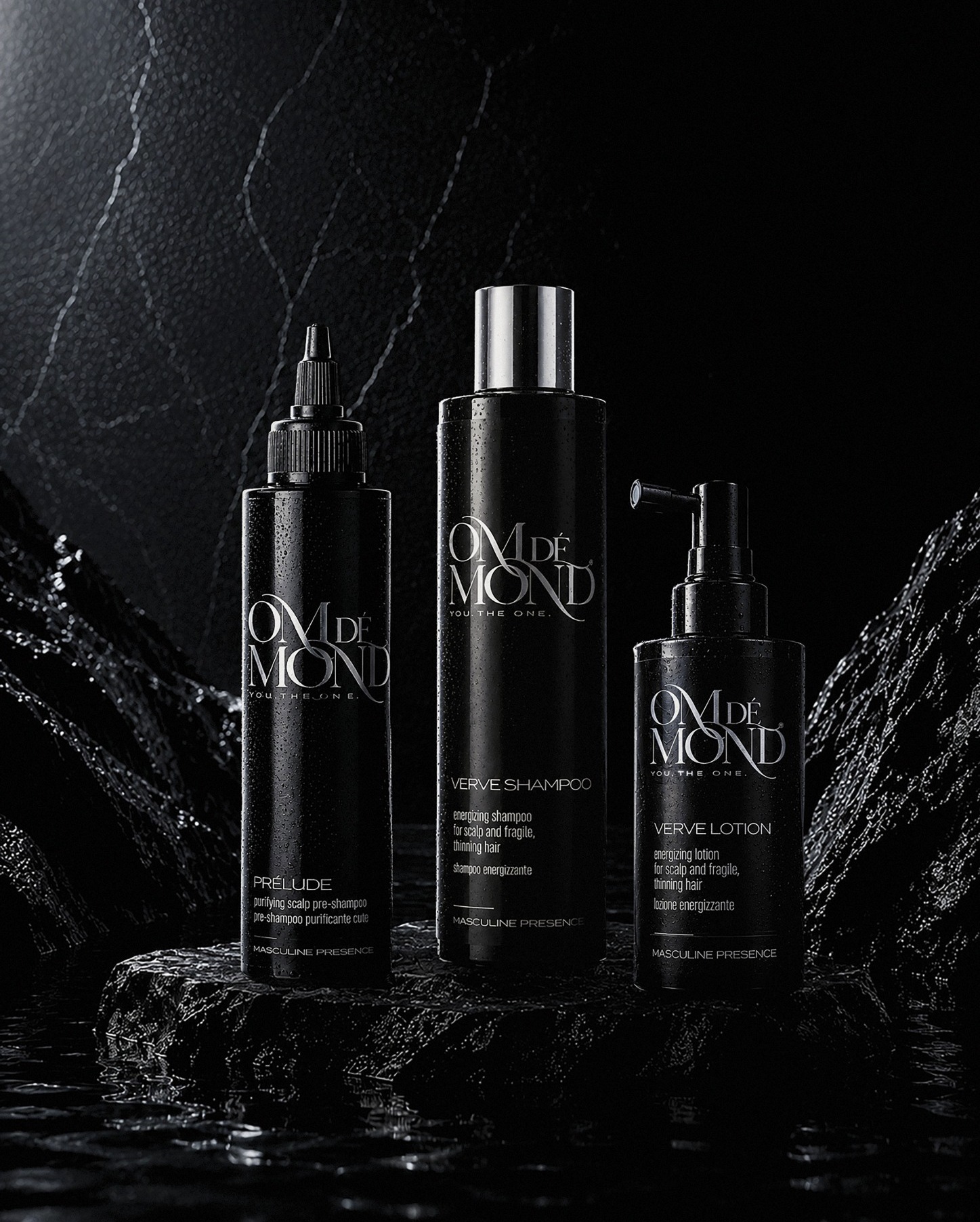 Om de Mond Verve System con Prélude, Verve Shampoo e Verve Lotion su rocce nere bagnate